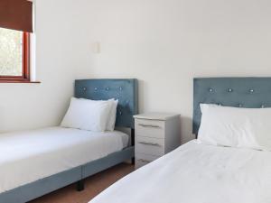 チェプストウにあるRadford Retreatのベッドルーム1室(ベッド2台、ナイトスタンド付)