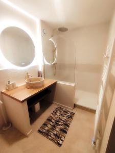 une salle de bain avec un lavabo et un miroir dans l'établissement Appartement cosy en centre-ville, à Calais