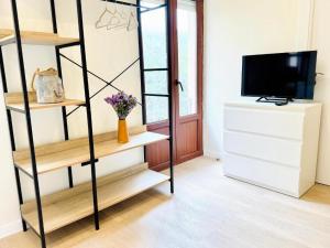 a living room with wooden shelves and a television at Santander suites and rooms atlántico in Santander