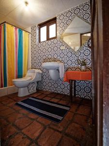 a bathroom with a toilet and a sink and a mirror at Apartamentos Otorongo Cuenca Ecuador in Cuenca