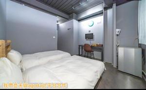 1 dormitorio con 2 camas y escritorio con teléfono en 新橙居-我們未與阿狗打訂房平台合作請勿在阿狗打訂房平台訂房, en Dalin 15 fotos más