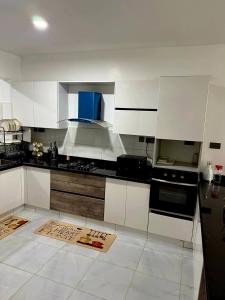 a kitchen with white cabinets and a blue at Book n Breeze in Nairobi +12 photos