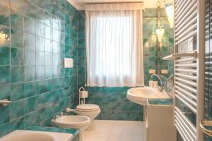 a green tiled bathroom with a toilet and a sink at Ca' Magno by Venicevillas, dimora storica in Venice +26 photos