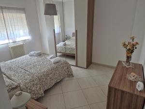a bedroom with a bed and a vase of flowers on a table at mirosa airport home in Macchie