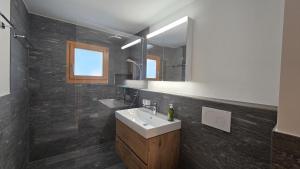 a bathroom with a sink and a mirror at LAAX Homes - Val Mulin 14,2 in Laax-Murschetg +13 photos