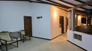 a room with chairs and a table and a white wall at Canmin Guest House in Galle