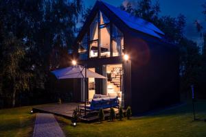een huis met een parasol en een stoel op een terras bij Dom w Starkowie, Sauna i Balia 