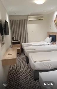 a hotel room with three beds in a room at فندق ضيف العزيزية in Ajyad
