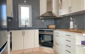 a kitchen with white cabinets and a sink at 3 Bedroom Beautiful Home In Årjäng in Årjäng