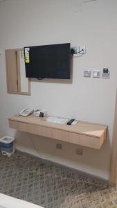a desk in a room with a television on the wall at فندق ضيف العزيزية in Ajyad