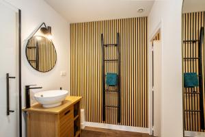 ein Badezimmer mit Waschbecken und Spiegel in der Unterkunft L'Authentique - Centre ville de Dax avec jardin in Dax