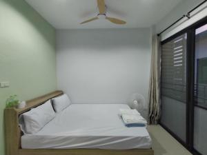 a bedroom with a bed with a ceiling fan and a window at Krabi Rooms - Appartment 6 in Krabi town