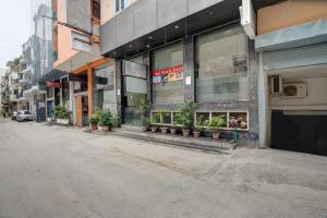 an empty street in front of a building with potted plants at Hotel City Lite Near Delhi Airport in New Delhi