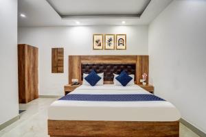 a bedroom with a large bed with blue pillows at Hotel City Lite Near Delhi Airport in New Delhi