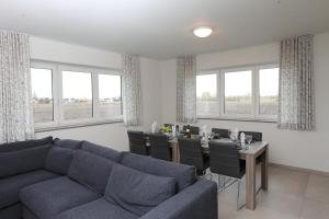 a living room with a couch and a table with chairs at Het Polderzicht in Mellet