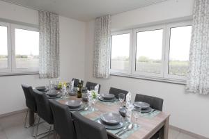 a dining room with a table and chairs and windows at Het Polderzicht in Mellet +26 photos