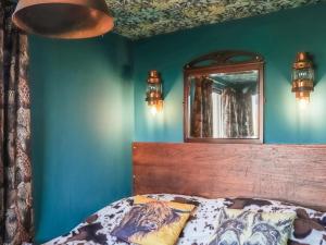 een slaapkamer met een bed en een spiegel aan de muur bij The Peacock Roost - Uk46297 in Brynkir