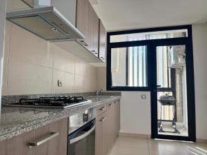 a kitchen with a stove top oven next to a window at Sea View Apartment & Swimming Pool in Sidi Bouqnadel