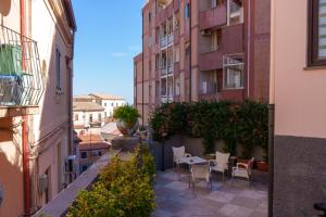 ein Balkon mit Tischen und Stühlen in einer Stadtstraße in der Unterkunft B E B Hotel Alexia in Catanzaro