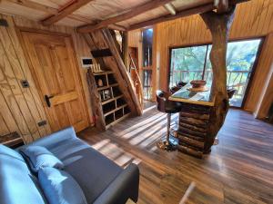 a living room with a couch and a table in a cabin at Casa de árbol Quillón in Quillón