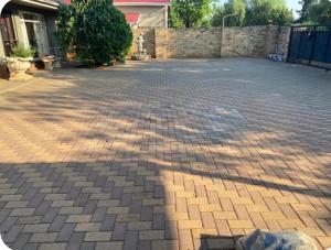 a brick parking lot with a brick wall and a driveway at Highway Haven in Stilfontein