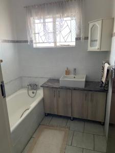 a bathroom with a tub and a sink and a window at Highway Haven in Stilfontein