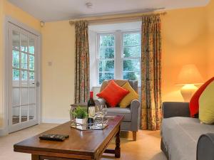 een woonkamer met een bank en een tafel bij Baldowrie Lodge in Ardler