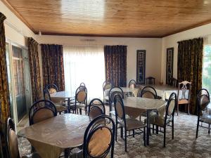 a dining room with tables and chairs and a window at Highway Haven in Stilfontein