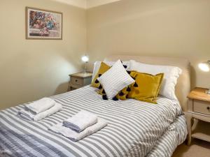 een slaapkamer met een bed met handdoeken erop bij Baldowrie Lodge in Ardler +9 foto's