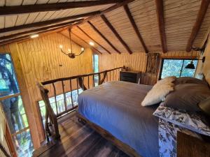 Un dormitorio con una cama en una habitación con ventanas. en Casa de árbol Quillón, en Quillón
