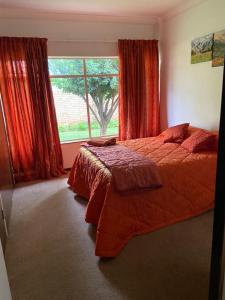 a bedroom with a bed and a large window at Highway Haven in Stilfontein