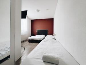 LimasにあるLogis Hôtel Novaのベッドが2つあり、壁が赤い寝室