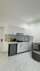 a kitchen with white cabinets and a couch in a room at Amour Homes in Quba +5 photos