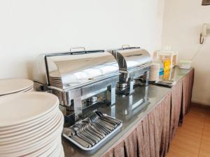 a kitchen with a counter with plates and a counter top with at Pontian Garden Hotel in Pontian Kecil