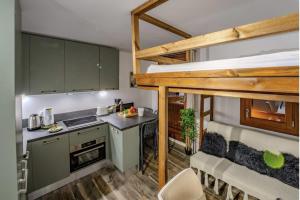 a kitchen with a loft bed in a tiny house at Ski in-out, Heart Val Thorens, Charming Studio, Wifi in Val Thorens