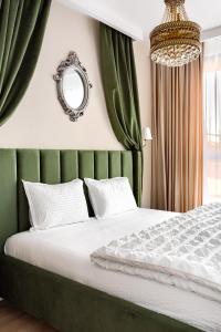 Schlafzimmer mit einem Bett mit grünen Vorhängen und einem Spiegel in der Unterkunft Sika Opulent Grand Apartment in Arad