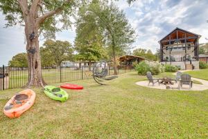 a group of kayaks on the grass next to a tree at Private Dock and Yard! Modern Getaway in Mabank in Enchanted Oaks