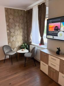Una sala de estar con televisión, mesa y sillas. en Gästehaus, en Neustadt