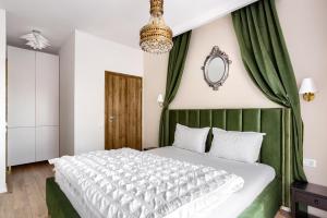 Schlafzimmer mit einem Bett mit grünen Vorhängen und einem Spiegel in der Unterkunft Sika Opulent Grand Apartment in Arad