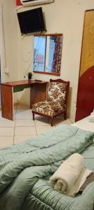 ein Schlafzimmer mit Bett, Stuhl und Schreibtisch in der Unterkunft To Σπιτι του Θωμά in Kardítsa