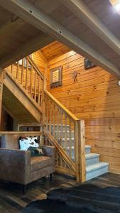 a wooden cabin with a staircase and a couch at The Cozy Family Wabasha Cabin in Wabasha