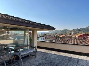 a bench on a balcony with a view of a city at La Terrazza in Piobesi dʼAlba
