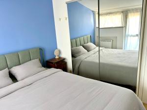 a blue bedroom with two beds and a mirror at La Terrazza in Piobesi dʼAlba