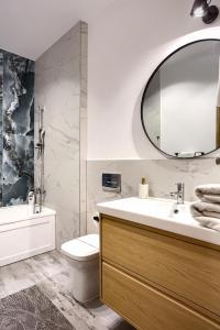 ein Badezimmer mit Waschbecken, Toilette und Spiegel in der Unterkunft Sika Opulent Grand Apartment in Arad