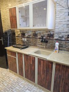 a kitchen counter with a sink and a window at Roaa Apartments in Al Qunfudhah