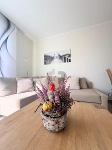 a vase of flowers on a table in a living room at DUENENZEIT App Nr 5 max 4 Pers in Dierhagen