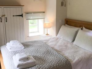 ein Schlafzimmer mit einem großen weißen Bett mit Handtüchern darauf in der Unterkunft Crabapple Cottage in Llanyblodwel