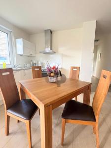 a wooden dining room table with chairs and a bowl of flowers at WINDLICHT App Nr 3 max 4 Pers in Dierhagen