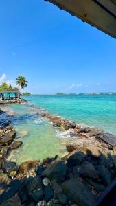 a beach with rocks and a palm tree and the ocean at Royal Sea Wind in Matara