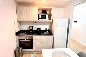 a small kitchen with a refrigerator and a microwave at Uriarte Suites in Buenos Aires